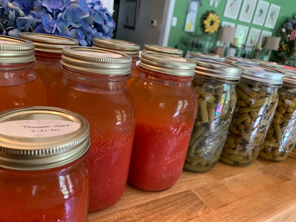 Canning jars of tomato juice and green beans