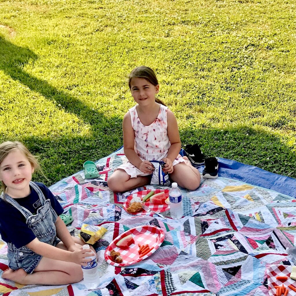 girls on quilt for picnic