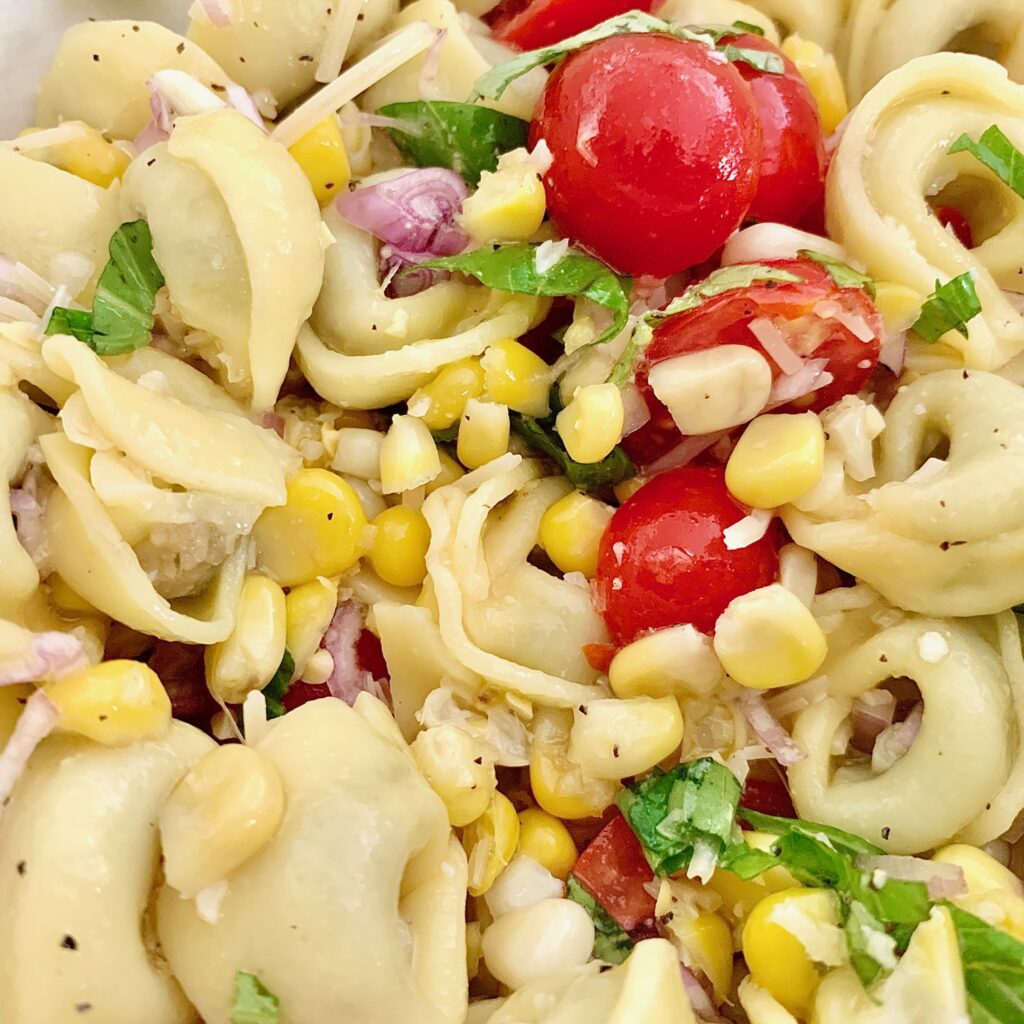 The BEST summer tortellini salad with fresh basil, corn, tomatoes, onion and a great dressing is a FAVORITE!!