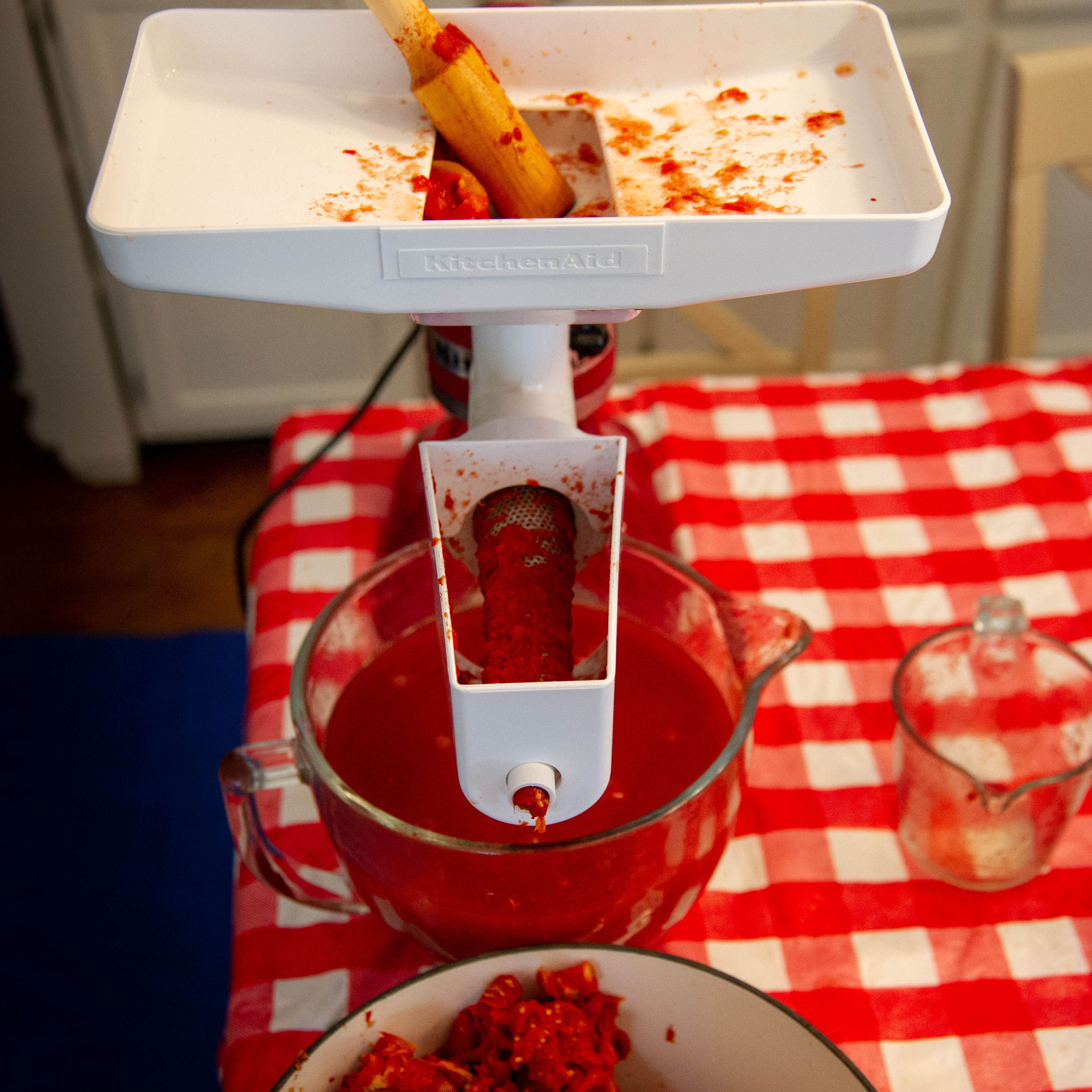 kitchen aid mixer with food grinder attached to make tomato juice