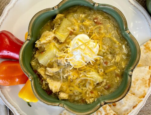 Bowl of Chicken Chile Verde soup with sour cream, cheese, mini peppers and cheese quesadillas