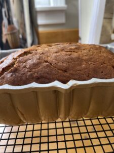 Banana bread in loaf pan on cooling rack