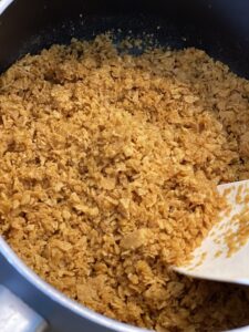 adding corn flake crumbs to butter for hash brown casserole topping