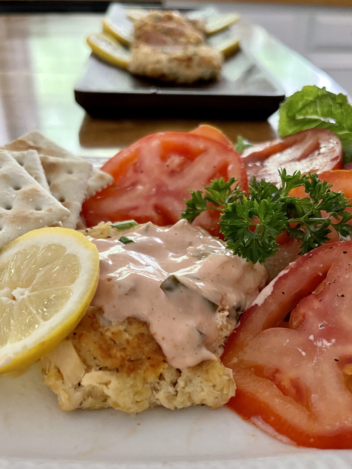 salmon patties with tomato and lemon and saltines