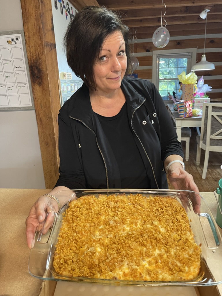 Holding a Hash brown potato casserole brought for a birthday party celebration