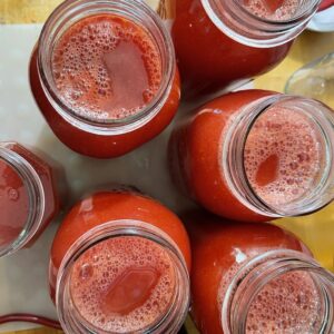 Overhead view of tomato juice in canning jars