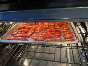 baking sheet with cherry tomatoes in oven