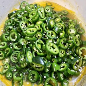 adding jalapenos to syrup to cook