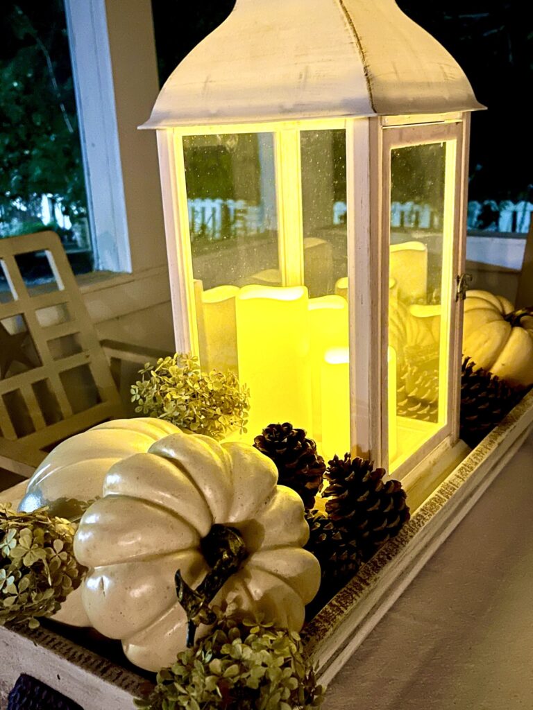 White lantern with pumpkins centerpiece