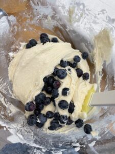 folding blueberries into blueberry coffee cake batter