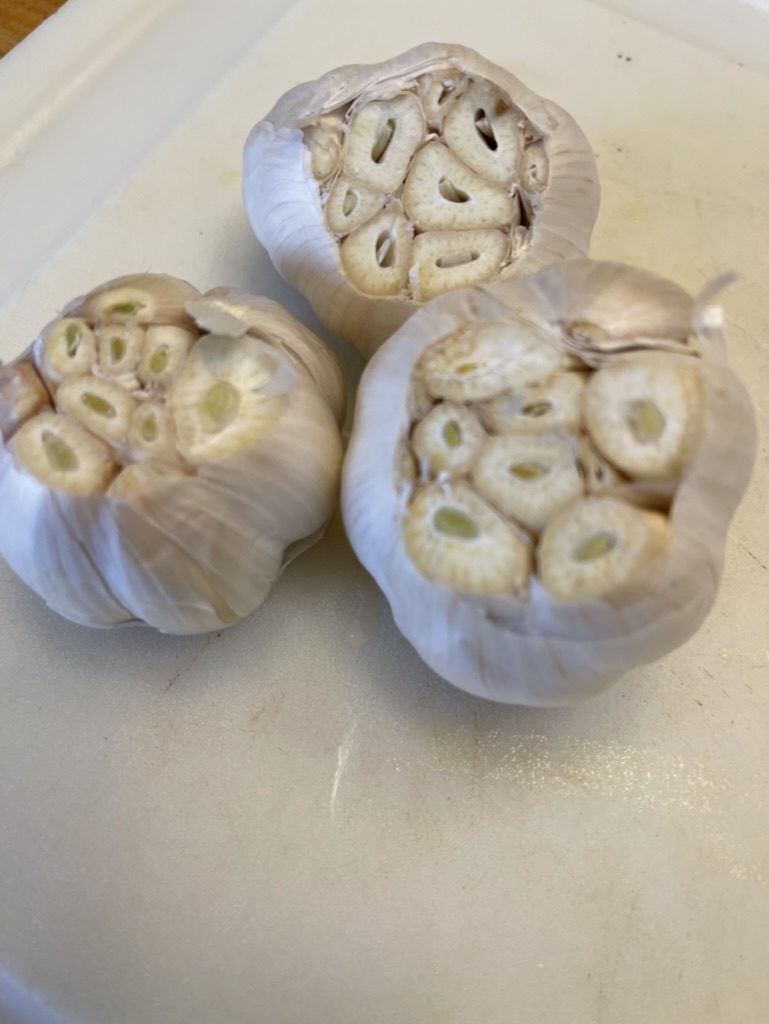 Cut off tops of garlic heads to add to cajun shrimp sheet pan recipe
