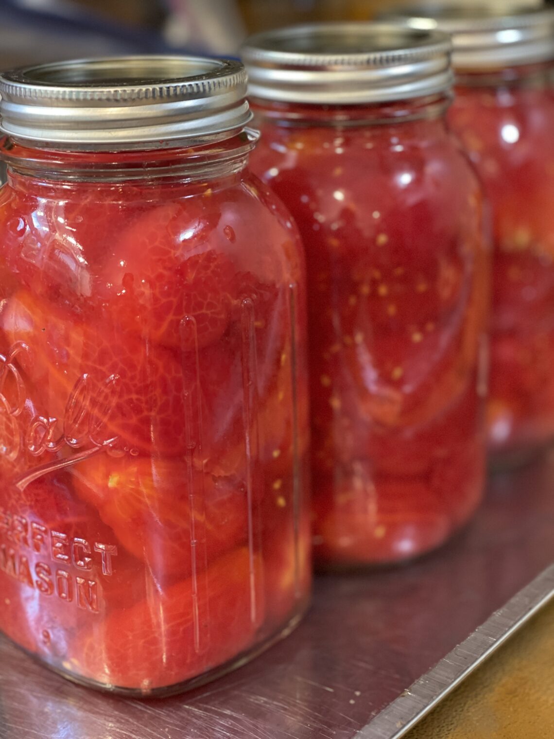 Filled jars of whole Roma tomatoes