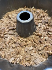 layer of cinnamon and pecan filling for cinnamon roll bundt cake in pan