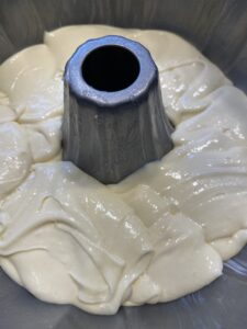 half cinnamon roll cake batter in bundt pan