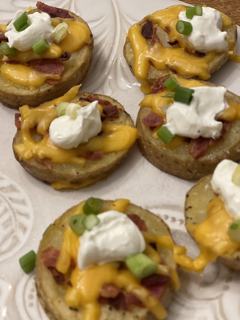 baked potato skins with cheese, bacon, sour cream and green onions added