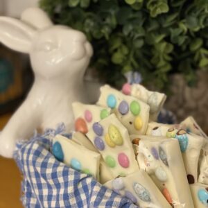 Easter bunny with white chocolate Easter candy filled wheelbarrow