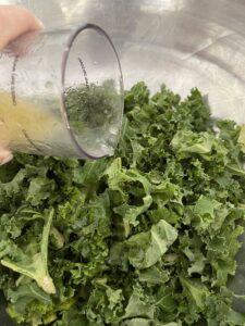 pouring dressing over kale