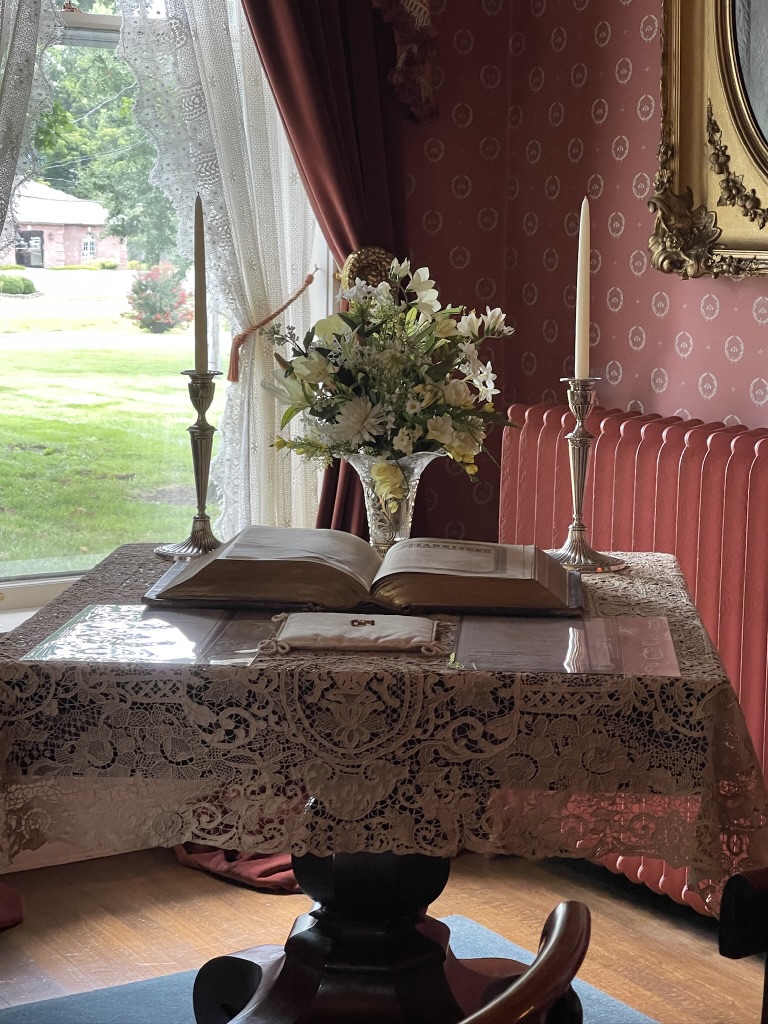 Victorian table holding the family Bible and wedding pillow