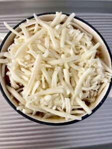 Grated cheese on top of toast and French onion soup