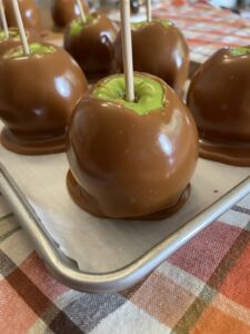 Dipped caramel apples cooling on baking sheet