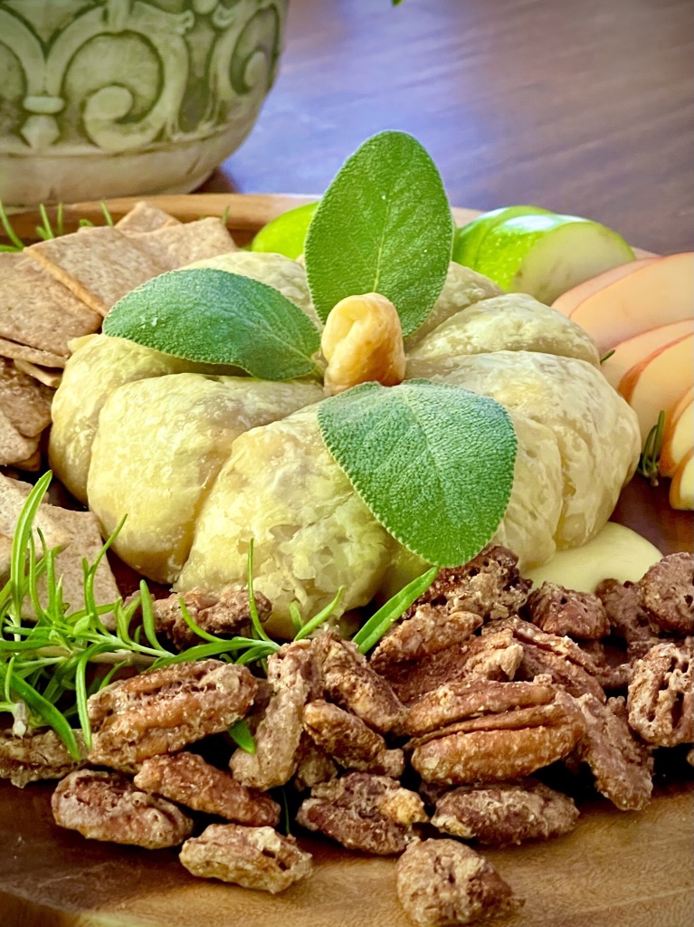 tray with baked brie with cinnamon nuts, apples and crackers