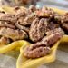 cinnamon pecans in yellow leaf dish