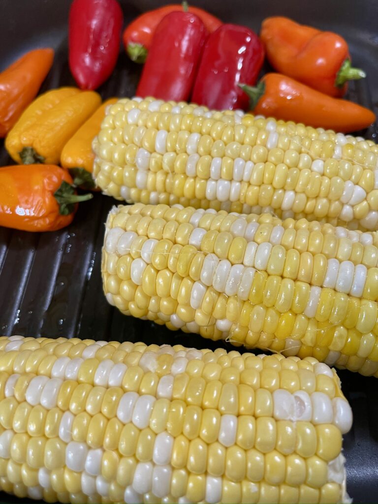 add corn, green onions and peppers to a grill pan