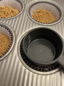 pressing crumbs into muffin tins
