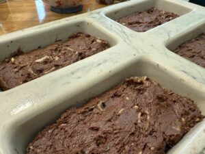 level double chocolate zucchini bread batter out in each loaf pan