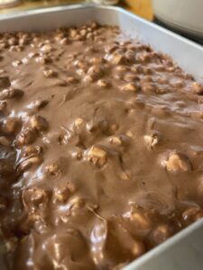 Add frosting over marshmallows on Mississippi Mud Cake