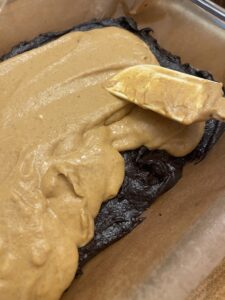 pumpkin cream cheese filling spread over half of brownies