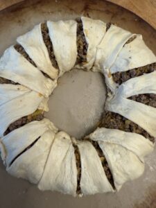 wrapping crescent rolls over taco ring meat mixture