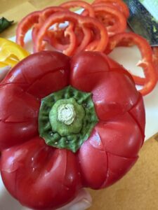 cut the tops off of peppers using a V shape to create serving containers for toppings to serve with taco ring