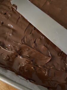 spreading melted chocolate over English toffee