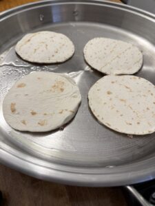 tacos cooking ground chicken side down for smashed chicken tacos