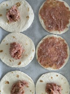 seasoned ground chicken added to tortillas for tacos
