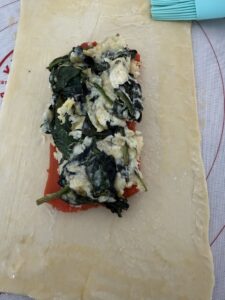 filling on top of salmon and egg wash added to edge of pastry