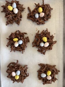 bird nests on parchment paper with 3 Cadbury mini eggs added