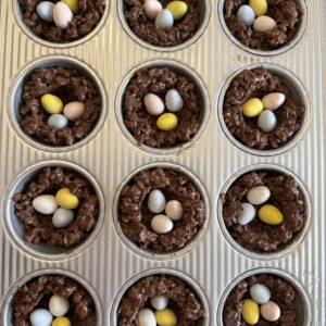 muffin tray filled with Cocoa Rice Krispies bird nests