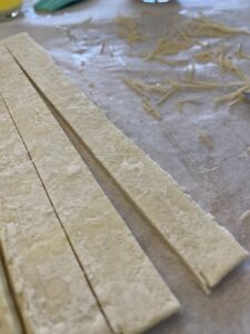 coat cut strips of puff pastry with butter