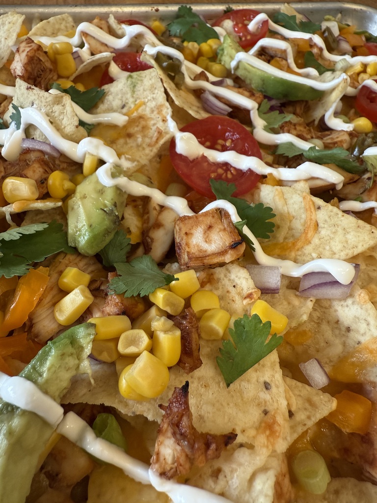 close up of drizzled summer sheet pan BBQ chicken nachos