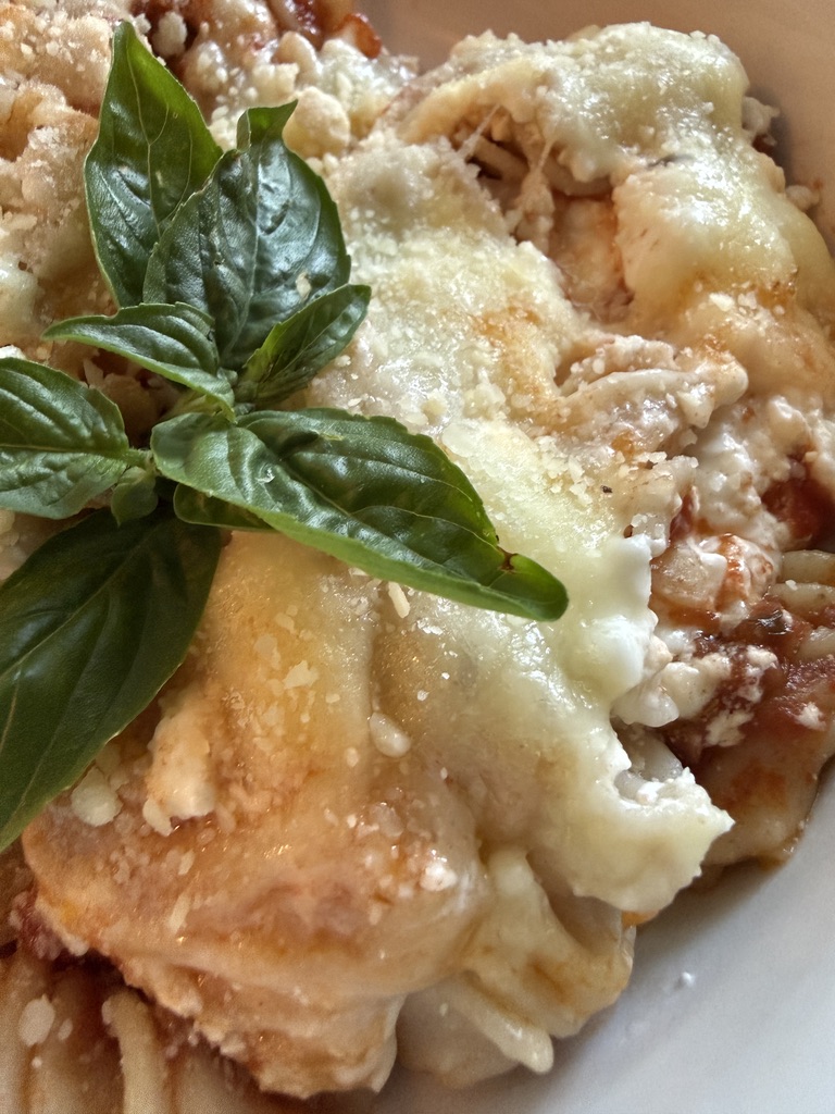 serving of baked rotini lasagna with basil added on top