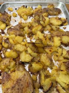 baked crispy potatoes cooling before adding to potato salad ingredients.