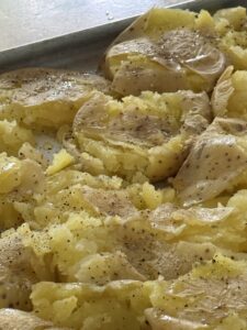 smashed potatoes on olive oil spritzed baking sheet lined with parchment paper