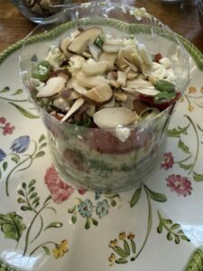 stacked Cobb salad in plastic solo cup on plate
