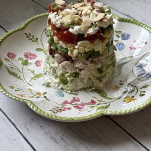 stacked Cobb salad on white barn boards