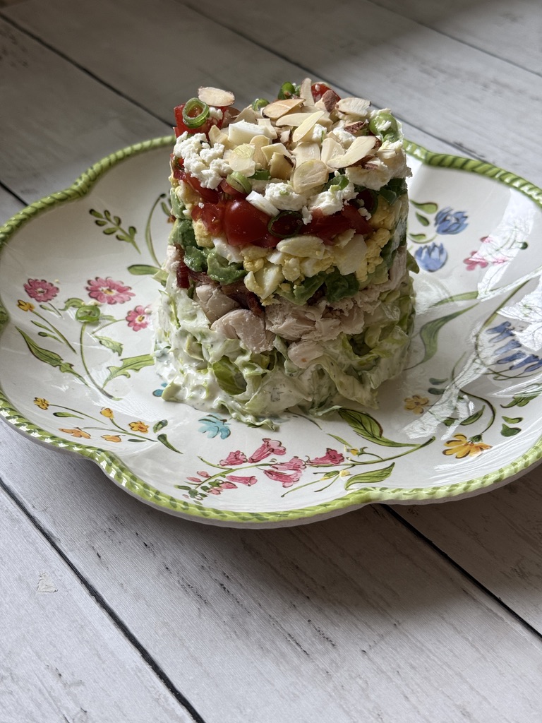 stacked Cobb salad on white barn boards
