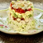 feature stacked Cobb salad on melamine plate
