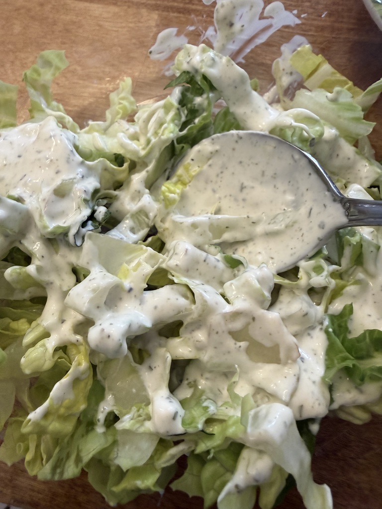 romaine lettuce mixed with Green Goddess dressing before layering Stacked Cobb Salad